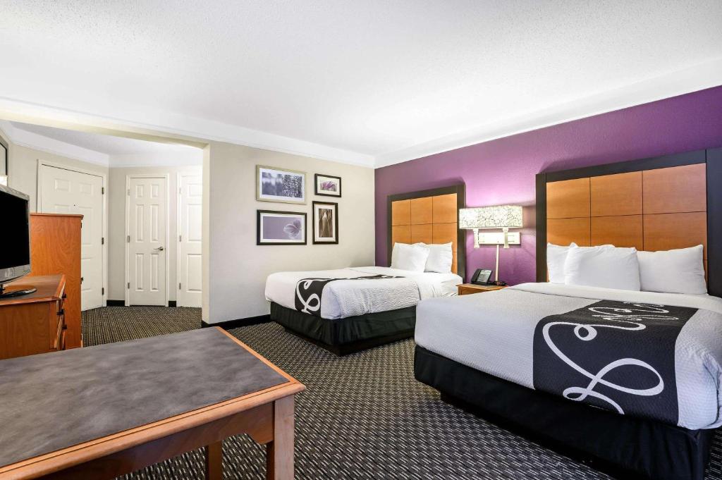 a hotel room with two beds and a flat screen tv at La Quinta by Wyndham Myrtle Beach Broadway Area in Myrtle Beach