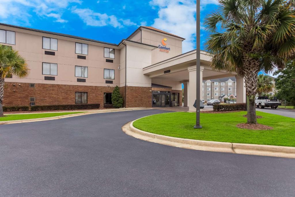 a hotel with a palm tree in front of a building at Comfort Suites North Mobile in Saraland