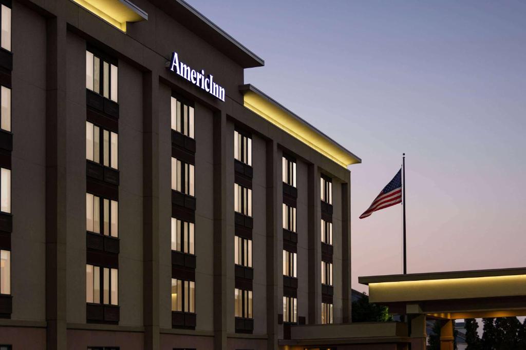an amazon building with an american flag in front of it at AmericInn by Wyndham Madison West in Madison
