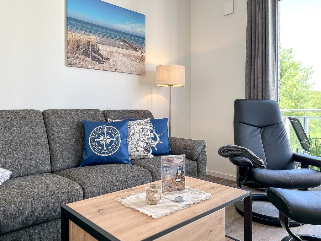 ein Wohnzimmer mit einem Sofa und einem Stuhl in der Unterkunft Weiße Villen Wohnung 20 in Boltenhagen