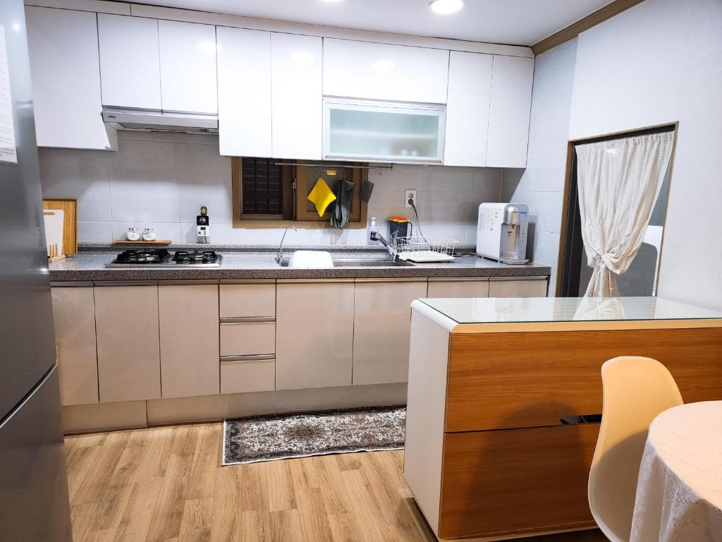 une cuisine avec des placards blancs et un comptoir dans l'établissement 3 Rooms for rent near Mapo-gu Office Station, Mapo-gu, Seoul, à Séoul
