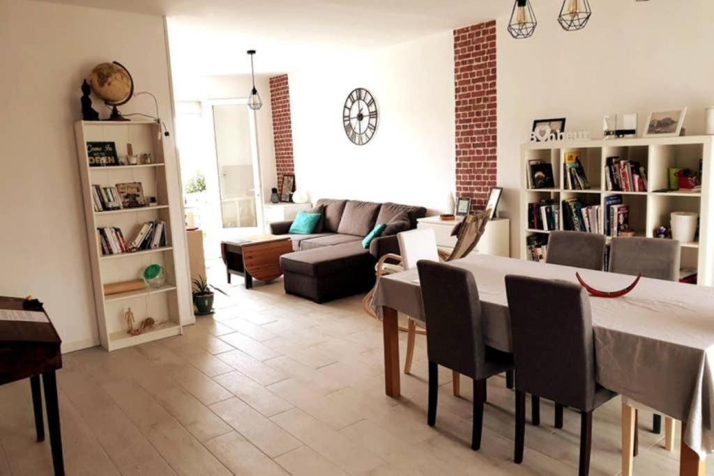 sala de estar con mesa y sofá en Maison familiale - ménage, serviettes, draps inclus, en Gaillac