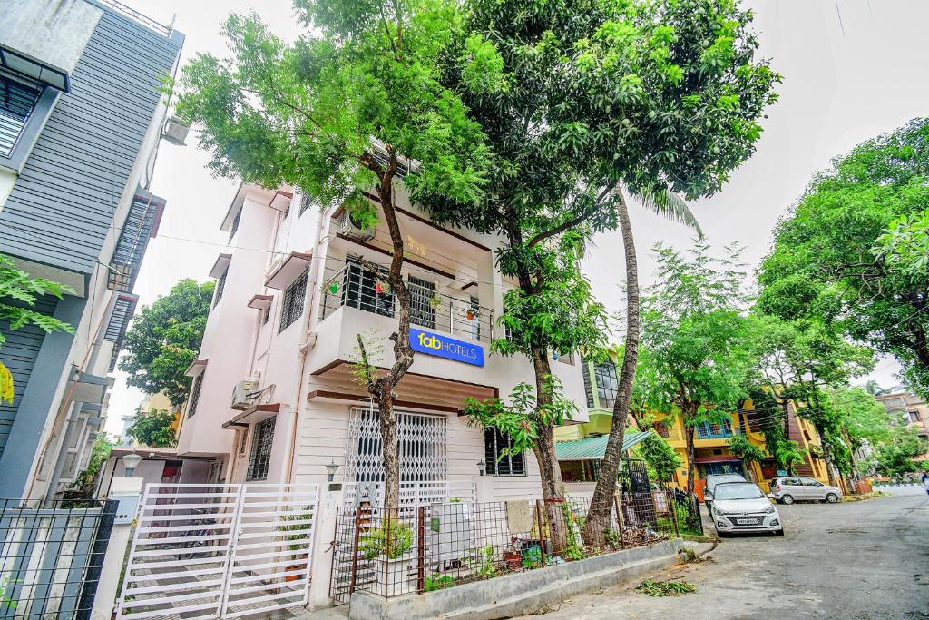 un edificio bianco con alberi di fronte di FabExpress Moon Residency a Calcutta