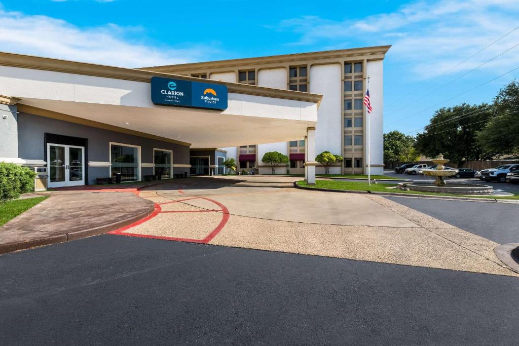 a hotel building with a red circle in front of it at Clarion Hotel San Angelo near Convention Center in San Angelo