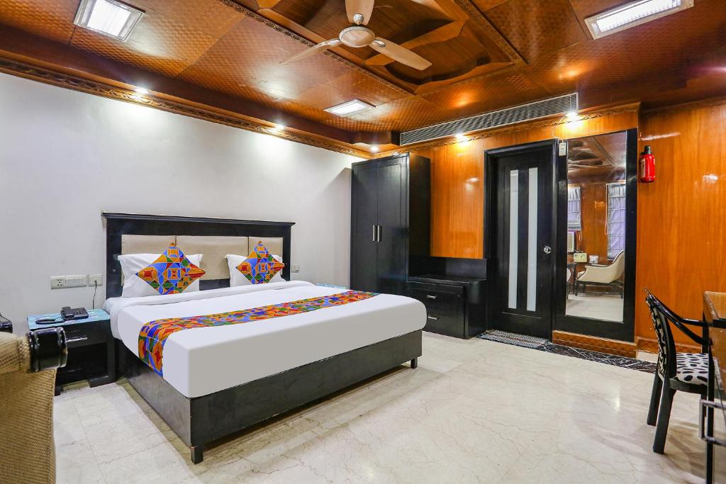 a bedroom with a large bed and a table and chairs at FabHotel Blue Moon Home Stay in New Delhi