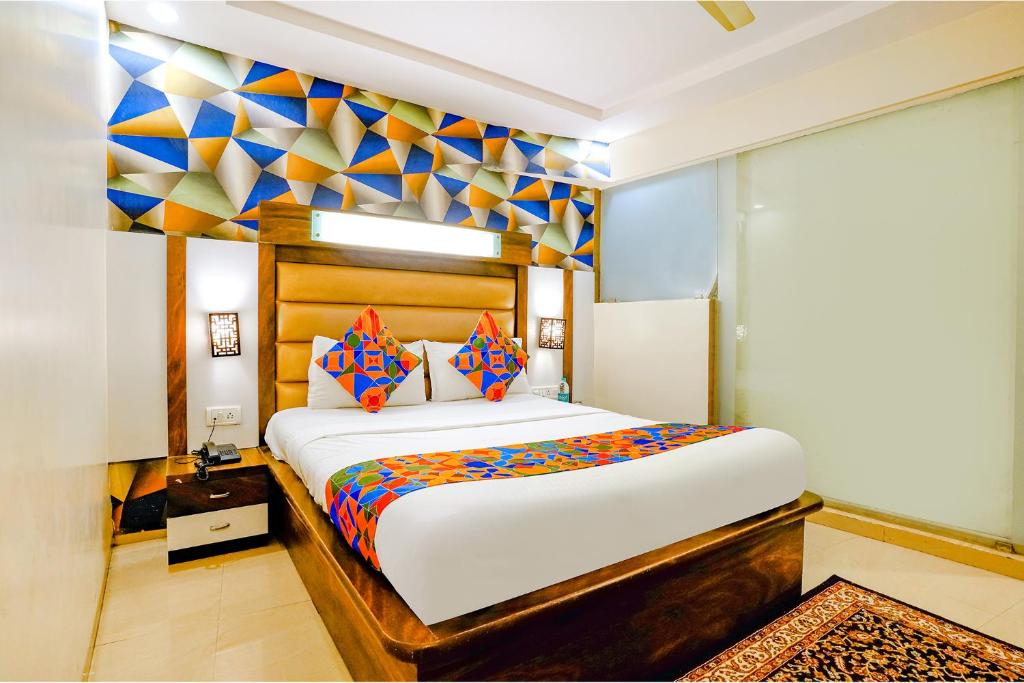 a bedroom with a large bed and a colorful wall at FabHotel Kwality Inn in Mumbai