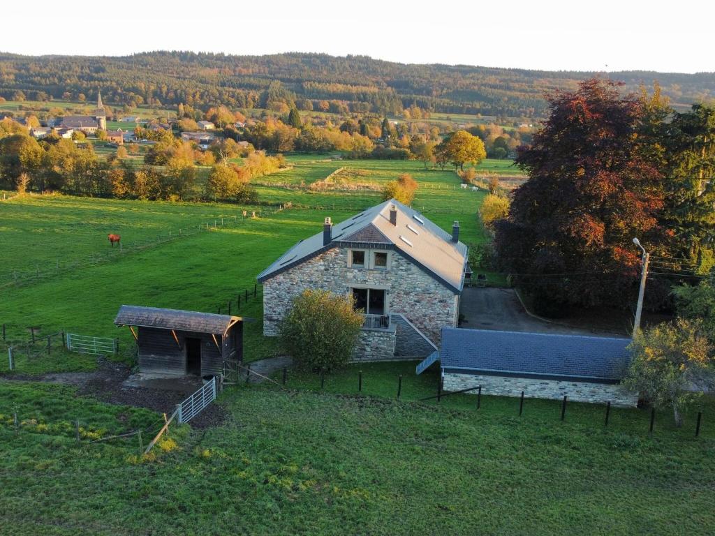 a small stone house in a field with a yard at Beautiful holiday home near Vielsalm with rural view in Vielsalm