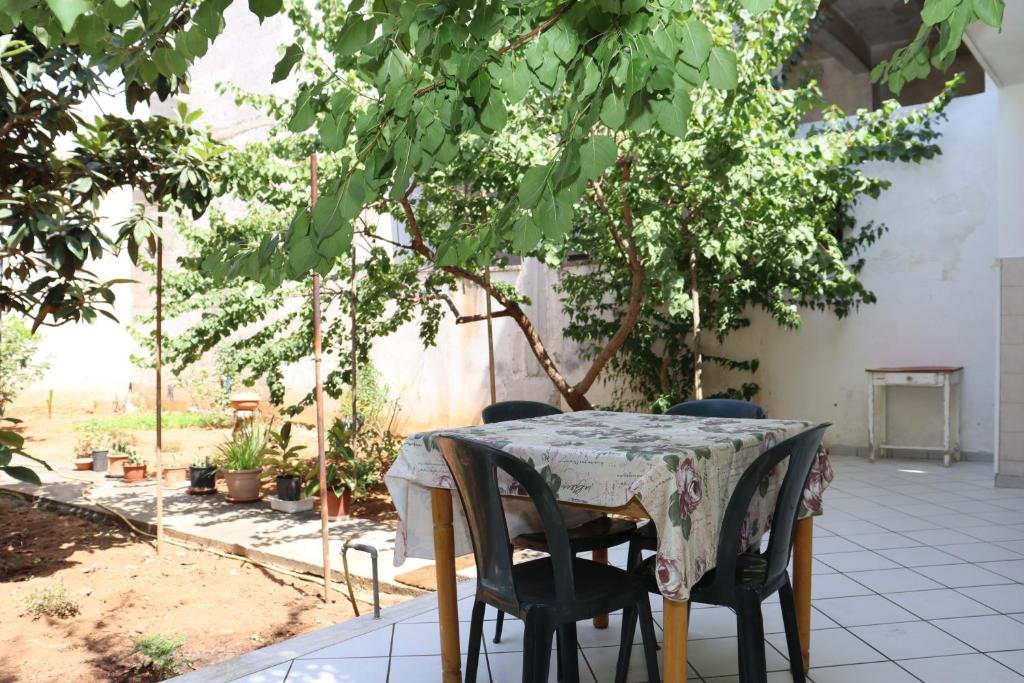 a table and chairs in a garden with a tree at Casa Vacanze Galatone delle Arance in Galatone