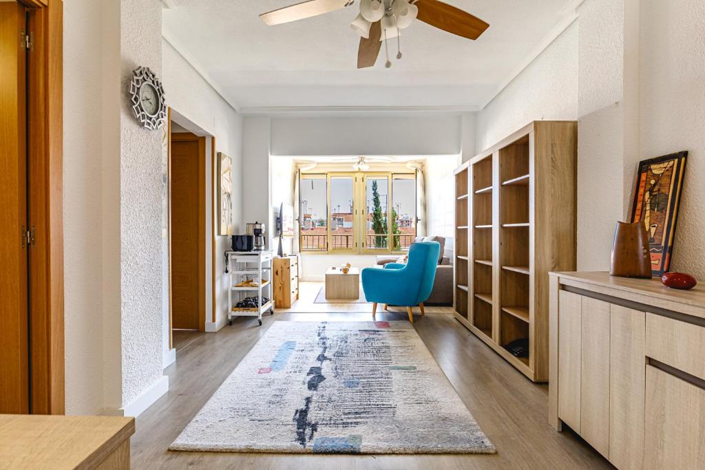 ein Wohnzimmer mit einem Deckenventilator und einem blauen Stuhl in der Unterkunft Stylish apartment with amazing views in Santa Pola