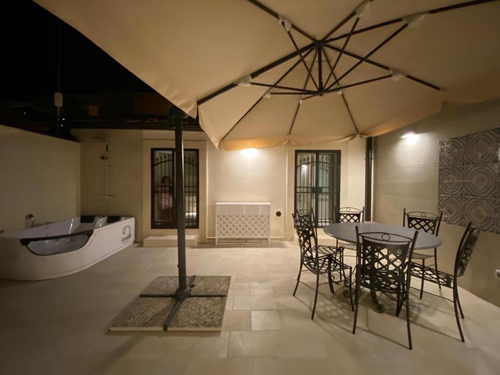 una sala da pranzo con tavolo e un grande ombrellone di La Dimora Degli Angeli a Noto
