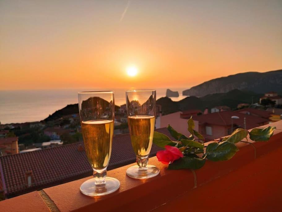 twee glazen champagne op een balkon met uitzicht op de zonsondergang bij Villa Mariuccia in Nebida