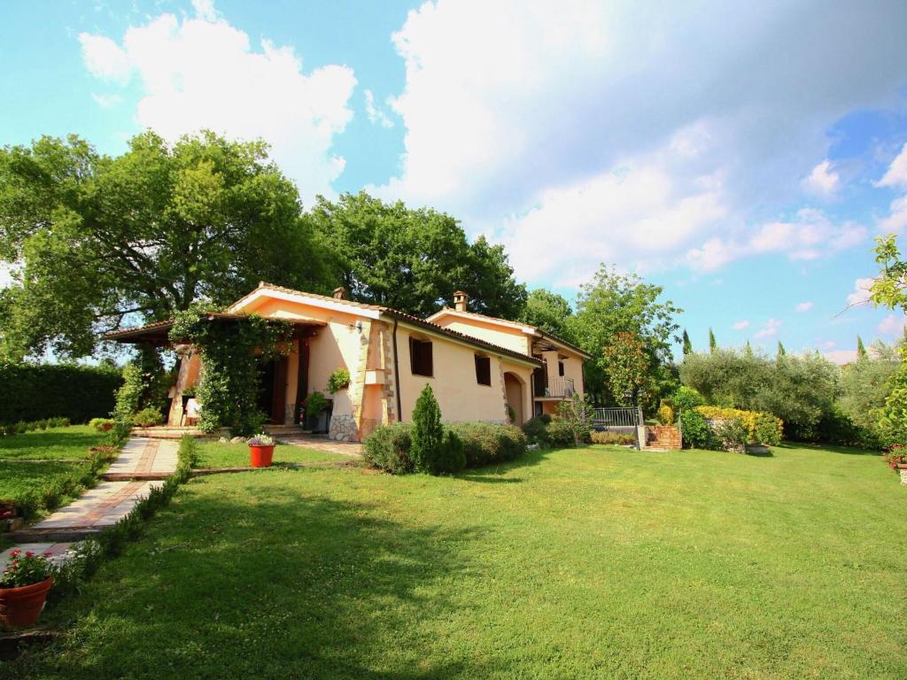 una pequeña casa en un patio con césped verde en Cosy holiday home in Selci with swimming pool, en Selci