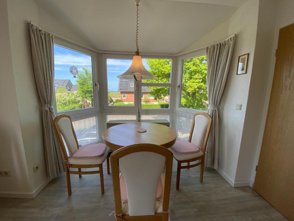 a dining room with a table and chairs and a window at Marina in Schönberger Strand