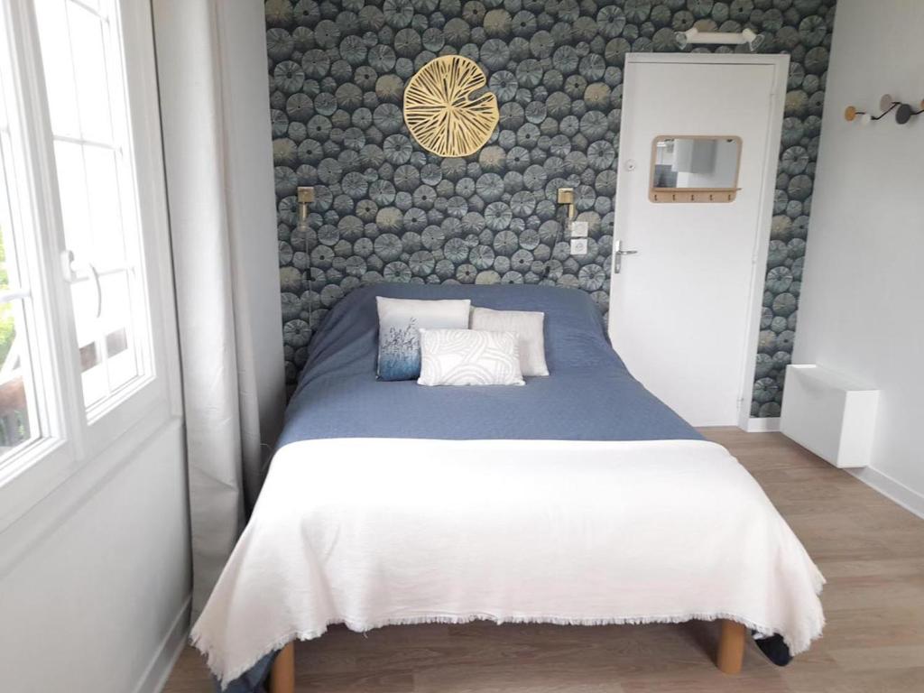 a bedroom with a bed and a wall of rocks at Studio proche du centre ville et de la plage in Villers-sur-Mer