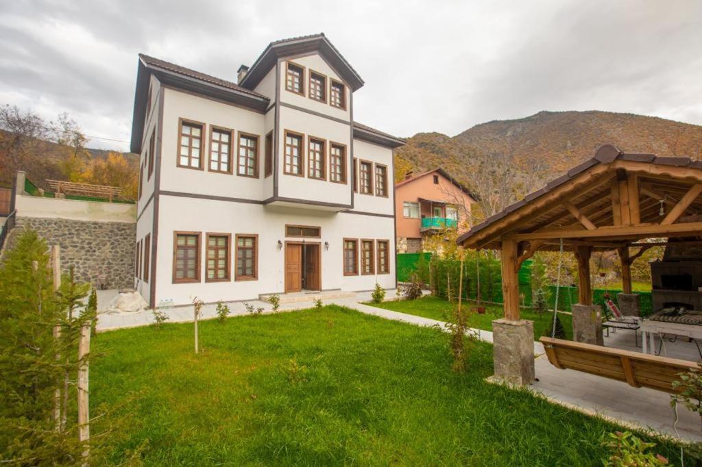 una gran casa blanca con un patio con césped y un pabellón en Odabaş Konağı, 