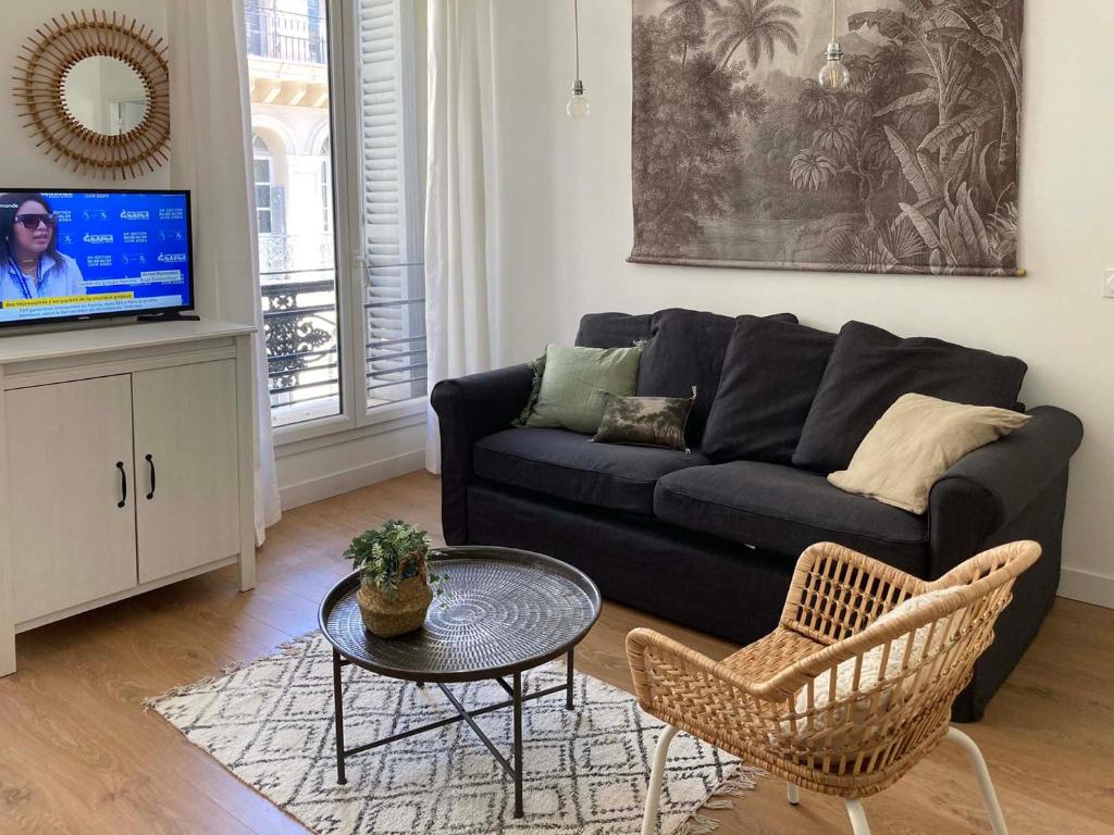 - un salon avec un canapé noir, une table et des chaises dans l'établissement T2 de charme au centre de Marseille, à Marseille