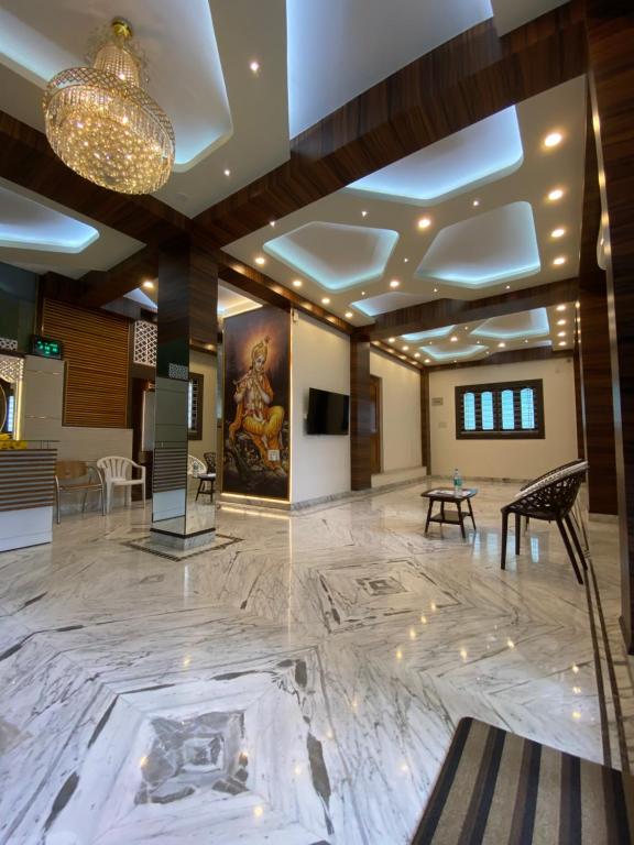een lobby met een grote marmeren vloer en een kroonluchter bij Krishna Kunja " A Quiet & Peaceful Stay " in Calcutta