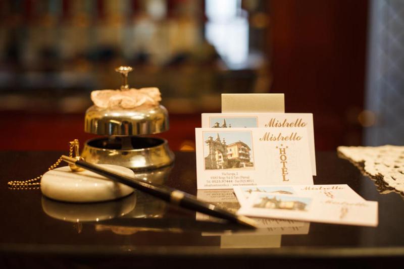 un tavolo con una bottiglia di profumo e una penna di Hotel Mistrello di Savoia a Borgo Val di Taro