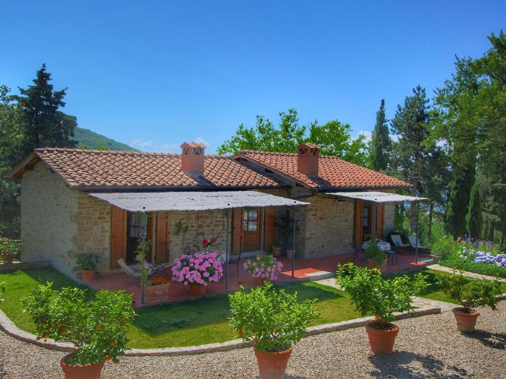 una pequeña casa con un jardín frente a ella en Detached villa for 6 pers with outdoor swimming pool, en Loro Ciuffenna