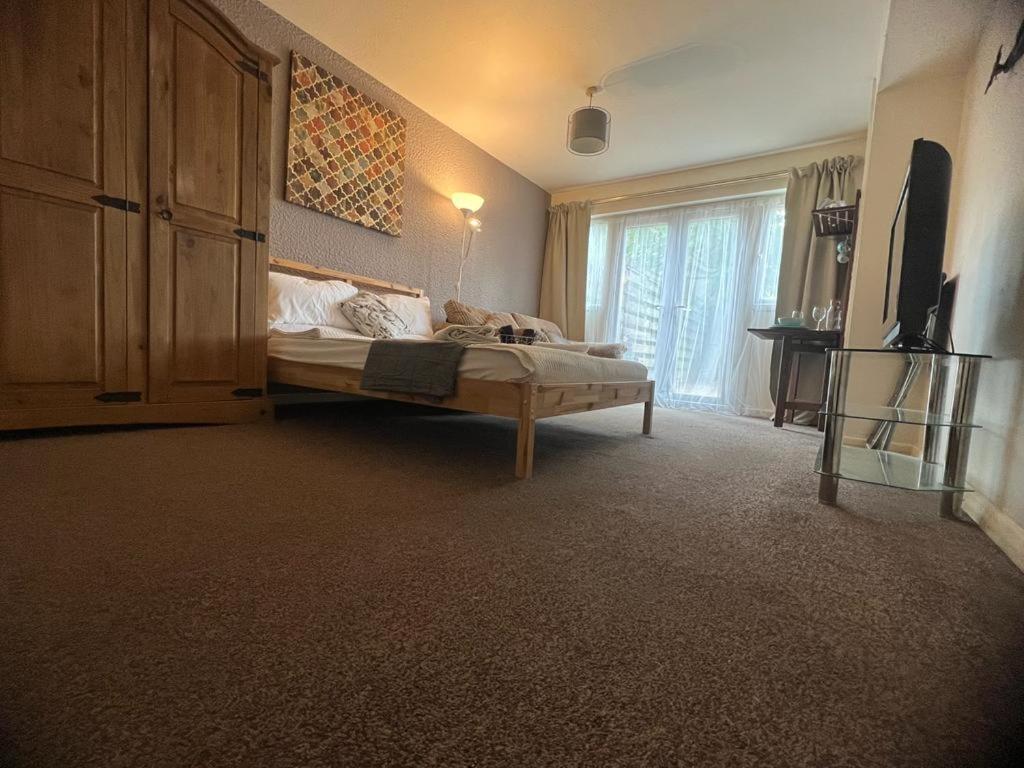 um quarto com uma cama e uma televisão em OAKhouse Raven em Basildon