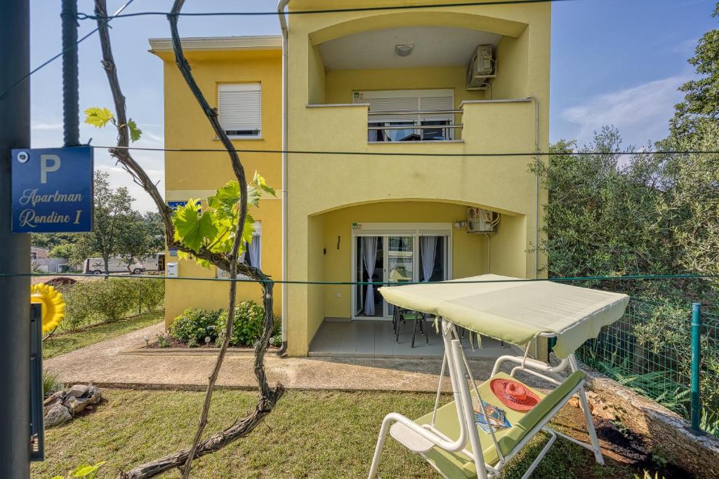 une table et une chaise devant une maison dans l'établissement Villa Rondine Apartments - Happy Rentals, à Novigrad