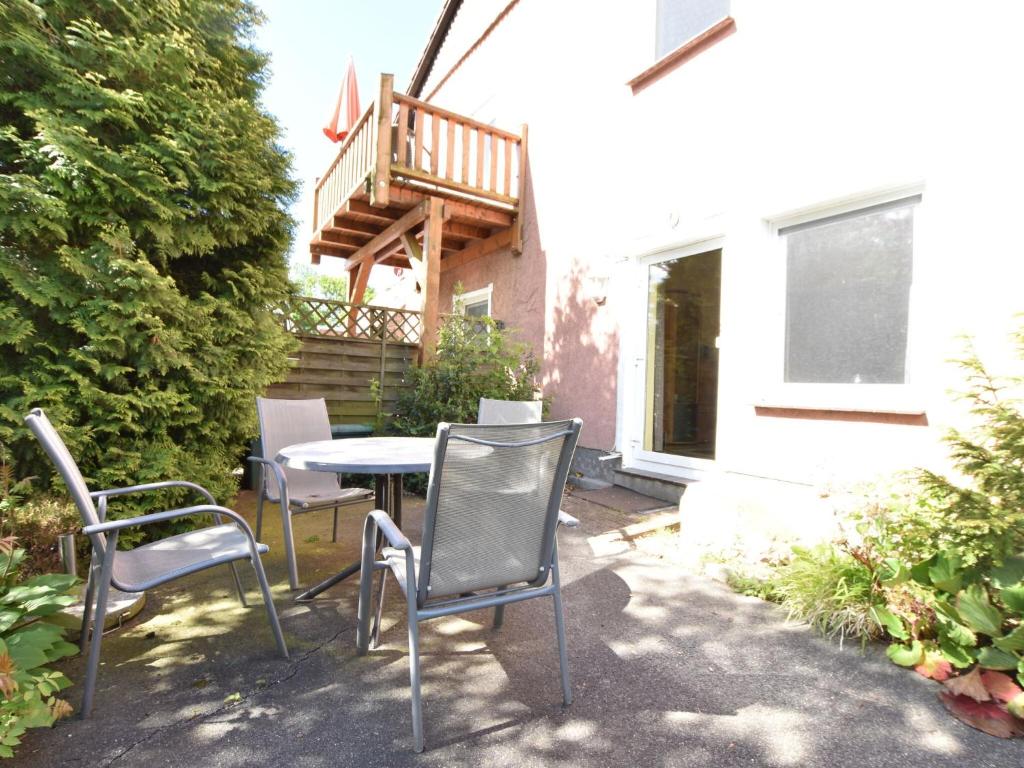 a patio with chairs and a table and a balcony at Cozy Apartment in Rerik near the beach in Rerik