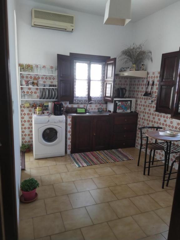a kitchen with a washing machine and a table at Patmos house Leo & Mary in Patmos