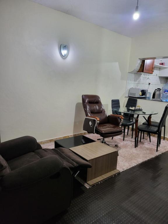 ein Wohnzimmer mit einem Sofa, Stühlen und einem Tisch in der Unterkunft G&G Executive Homes NAKURU in Nakuru