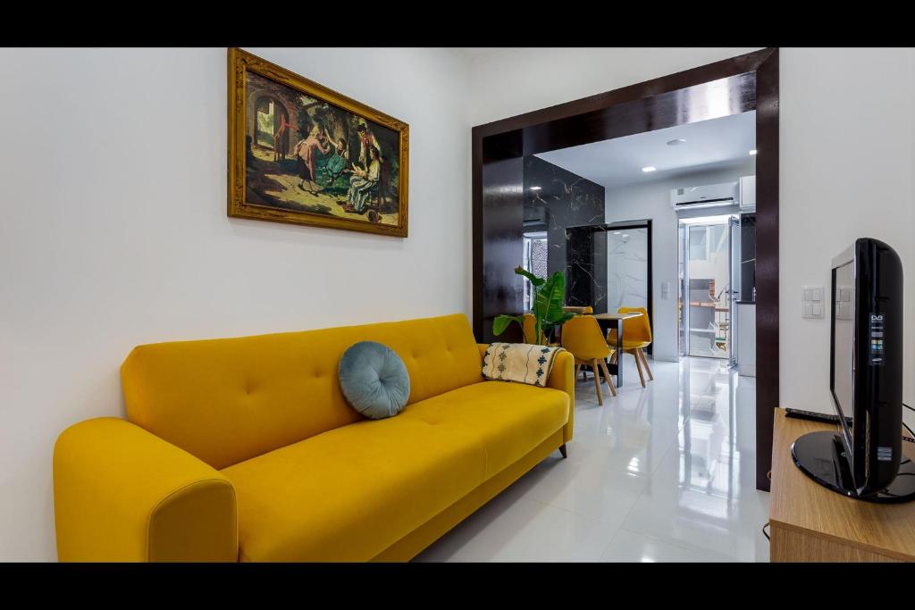 Stunning Flat With Jacuzzi in Silves by LovelyStay في سيلفيس: أريكة صفراء في غرفة المعيشة مع تلفزيون