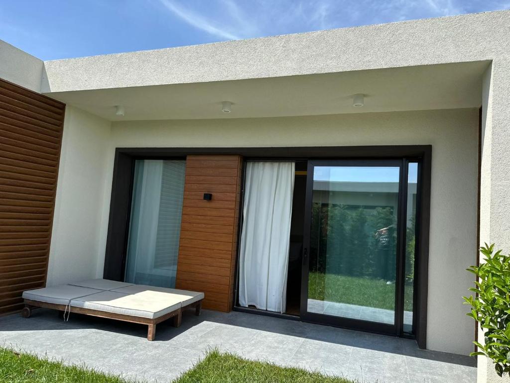a house with a patio with a bed and sliding glass doors at Sea breeze Villa in Nardaran