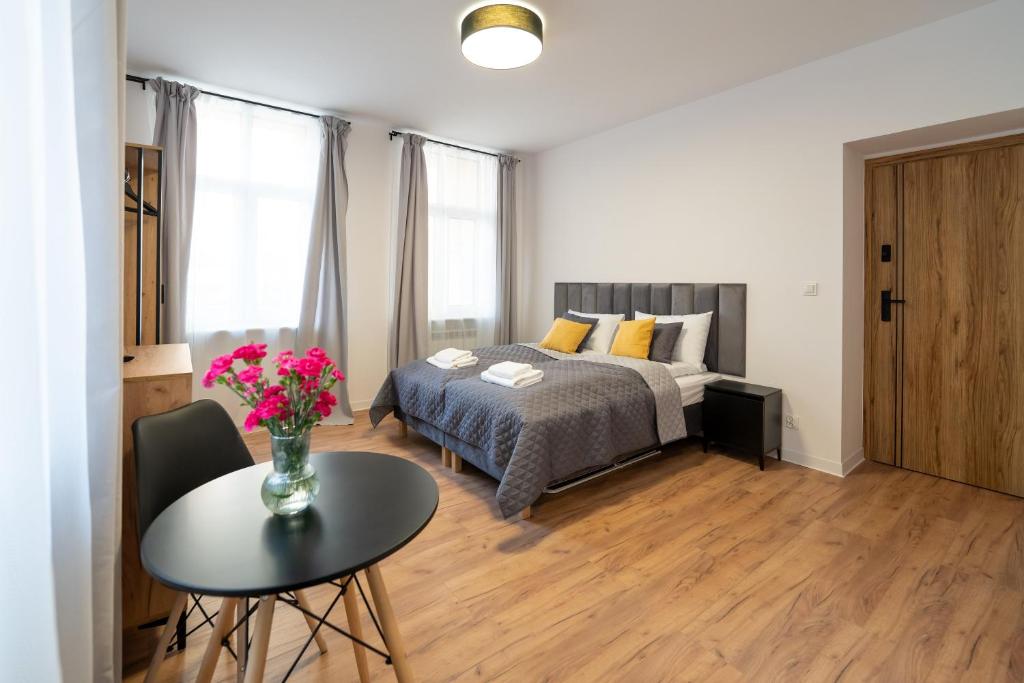 a bedroom with a bed and a table with flowers on it at Apartamenty Słowackiego 16 in Poznań