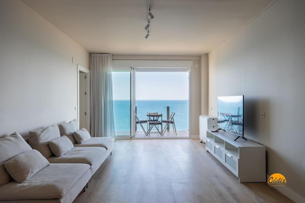 een woonkamer met een bank en uitzicht op de oceaan bij Malibu by Cadiz Time in Cádiz