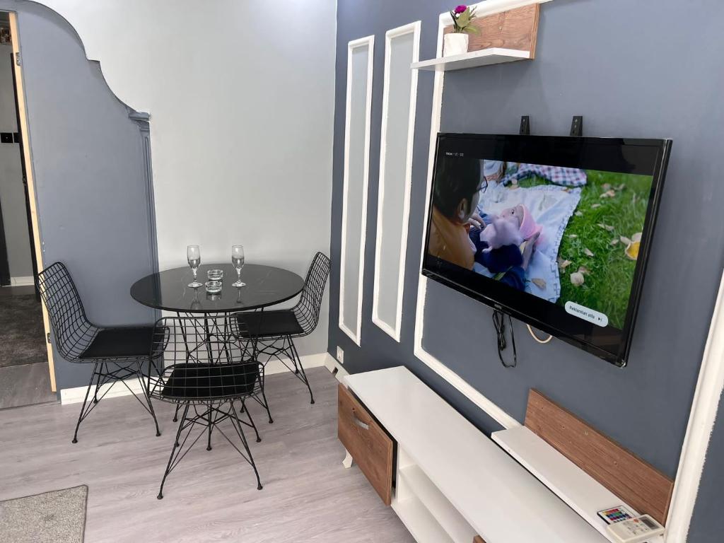 a living room with a table and a tv on a wall at baran suites in Istanbul