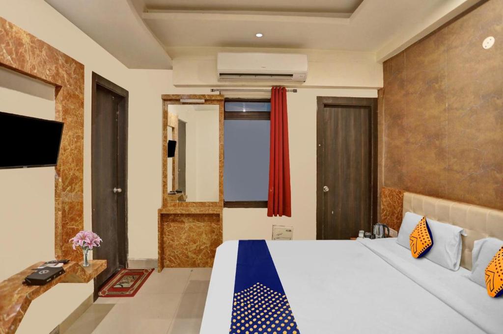 ein Hotelzimmer mit einem Bett und einem TV in der Unterkunft Hotel Kamdhenu inn Prayagraj in Lukerganj