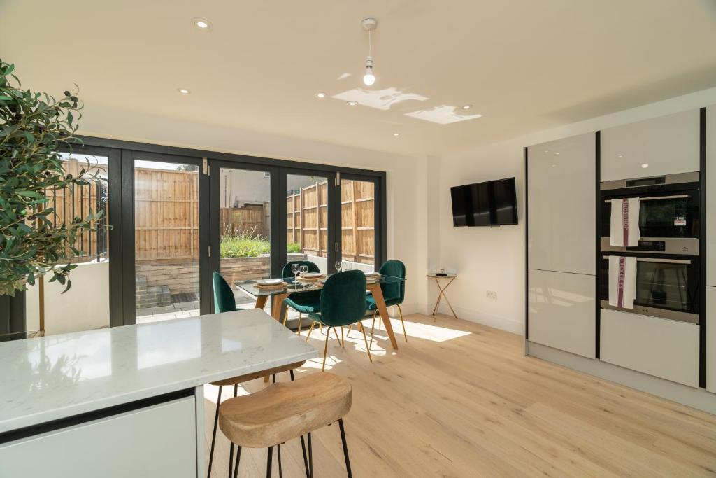 uma cozinha e sala de jantar com mesa e cadeiras em 4 Bedrm House Greater London em Londres