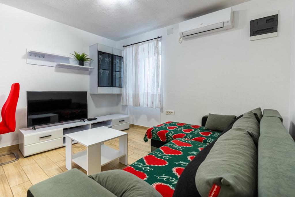 a living room with a couch and a tv at Apartman Robert Cres in Cres