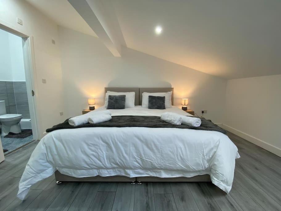 een slaapkamer met een groot wit bed met 2 lampen bij 221 Soho 2 in Birmingham