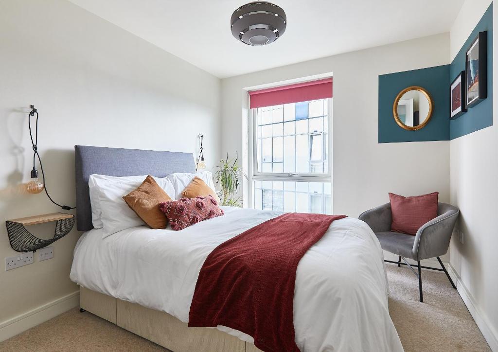 a bedroom with a large bed and a chair at The Glassworks by Ritual Stays in Hemel Hempstead