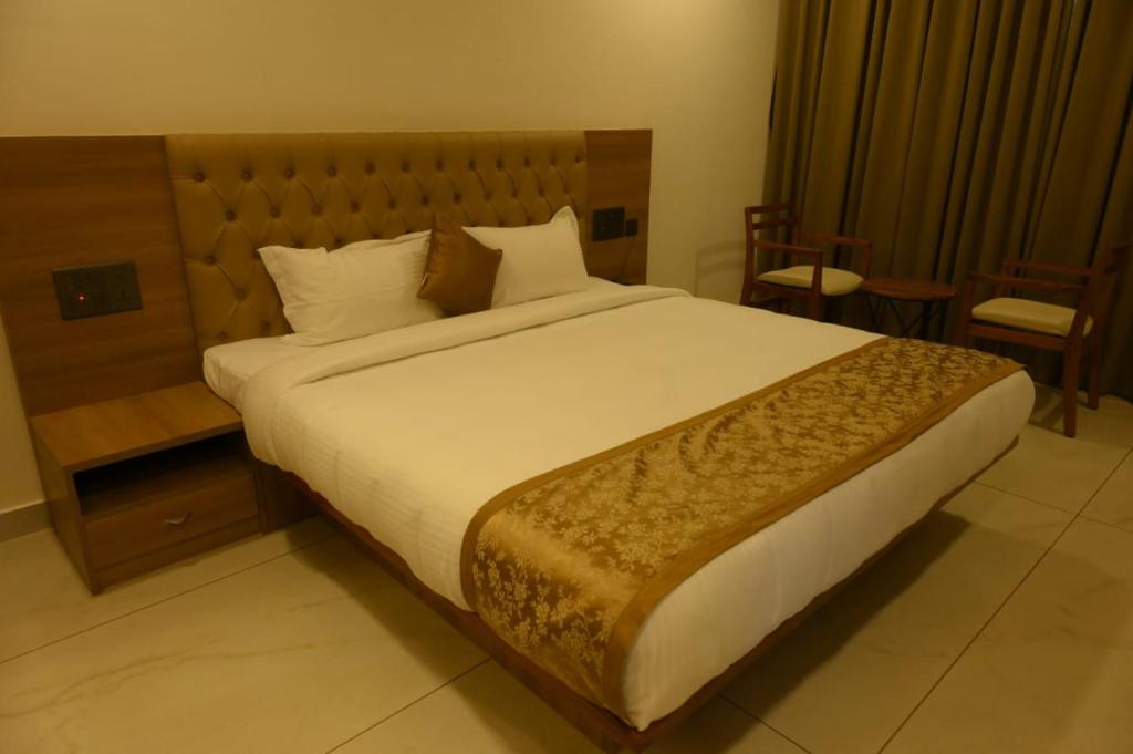 uma cama grande num quarto de hotel com em SHRREYAS INN em Kundapur