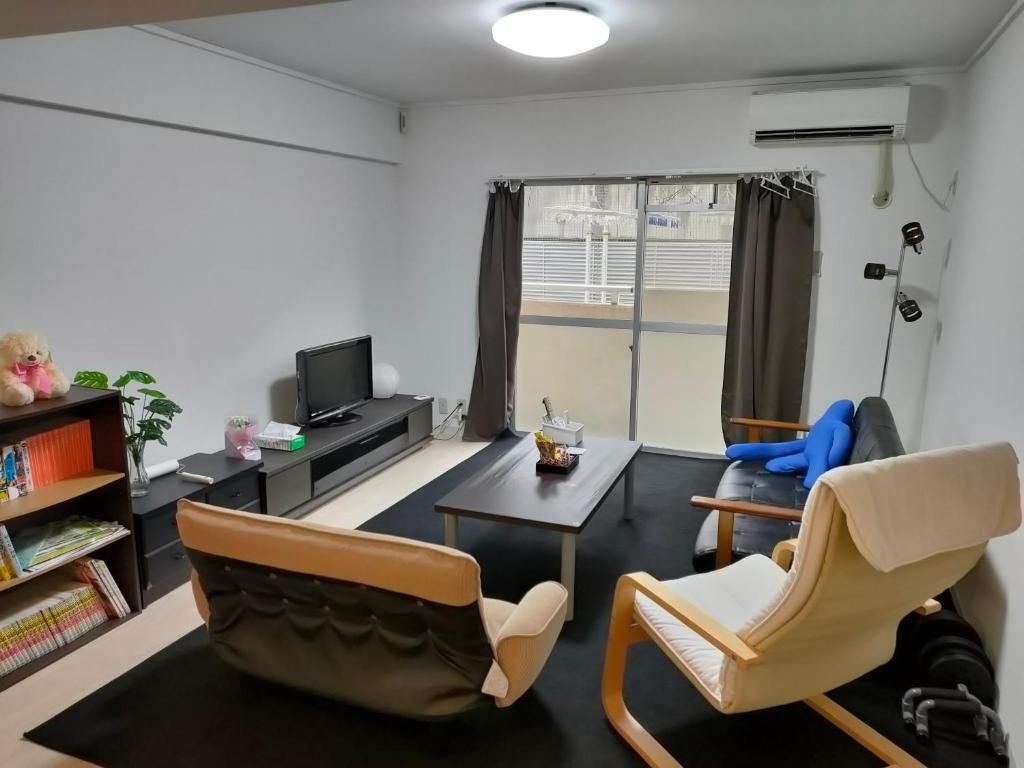 uma sala de estar com duas cadeiras e uma mesa em 広い60㎡　2LDK　前橋市の中心街にあるマンションの1室 em Maebashi