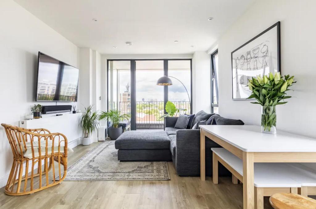 uma sala de estar com um sofá e uma mesa em Modern 1 bed l City views l Work Space em Londres