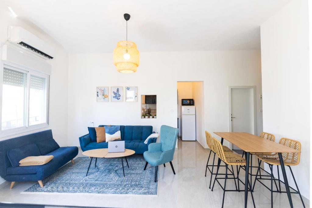 a living room with a blue couch and a table at H-nachala in Tel Aviv