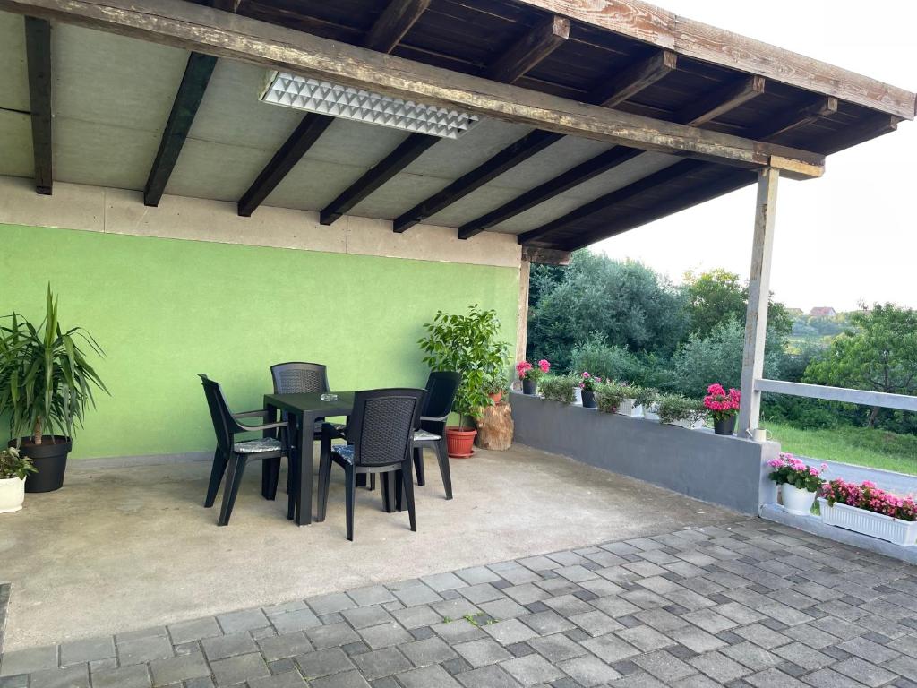 um pátio com uma mesa e cadeiras e uma parede verde em Sobe kod bolnice Paprikovac em Banja Luka
