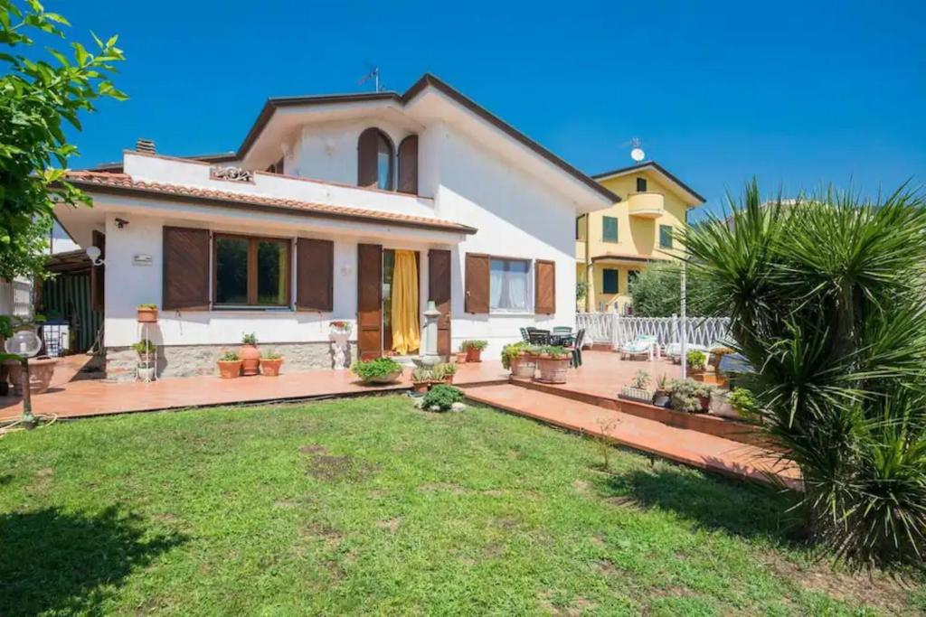 een wit huis met een tuin met een gazon sidx sidx sidx bij La mia casa tra cielo e mare in Massarosa