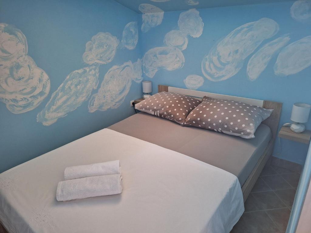 Mila في Kaštel Novi: سرير في غرفة مع سحب مرسومة على الحائط