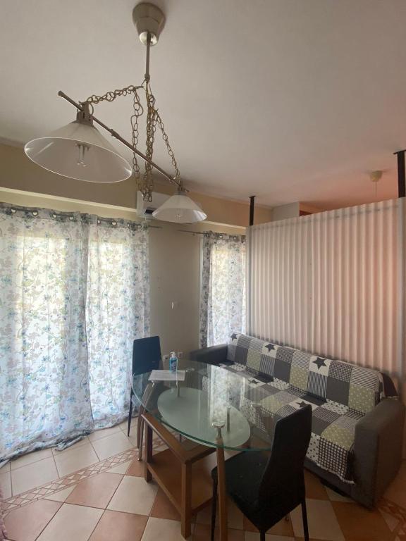 uma sala de estar com uma mesa e um sofá em Αρέθουσα easy view em Chalkida