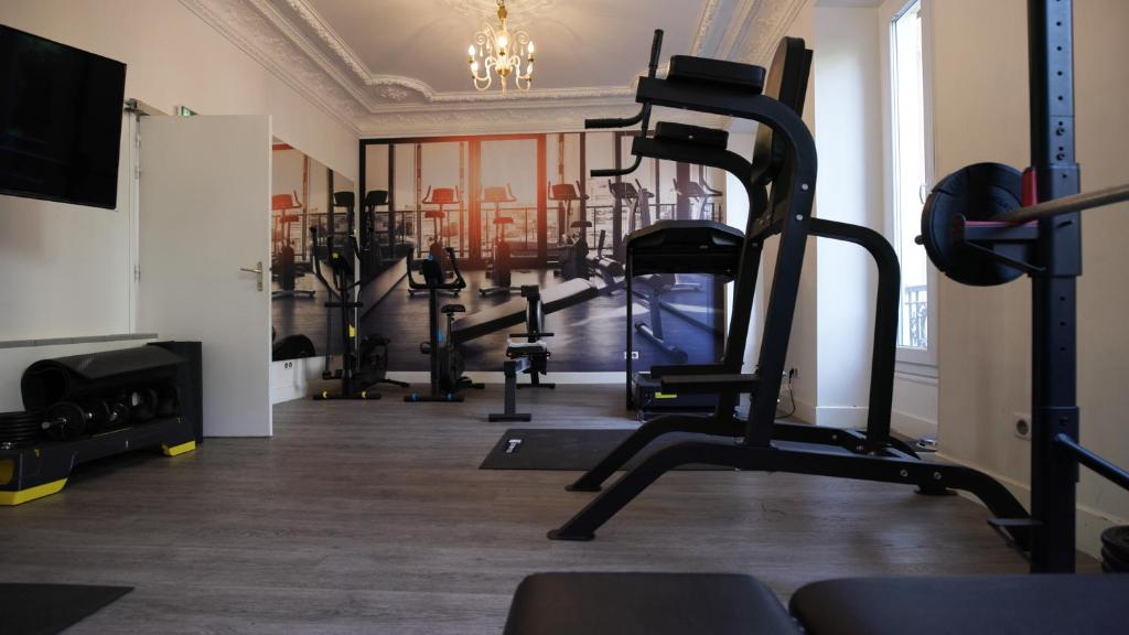 un gimnasio con varias máquinas de correr en una habitación en Hotel Busby, en Niza