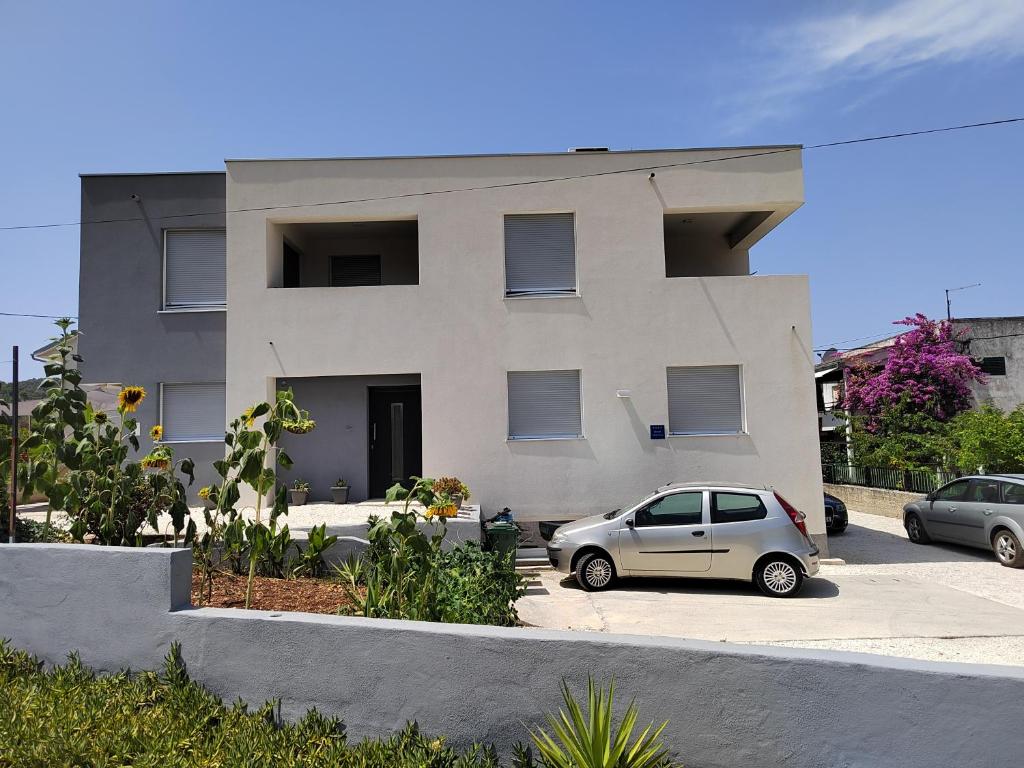 a white house with two cars parked in front of it at TiaMar in Slatine