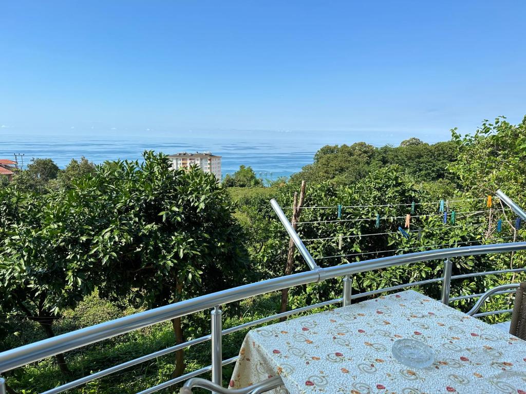 einen Tisch auf einem Balkon mit Meerblick im Hintergrund in der Unterkunft Delpina APART - Doğa içinde deniz manzaralı in Pazar