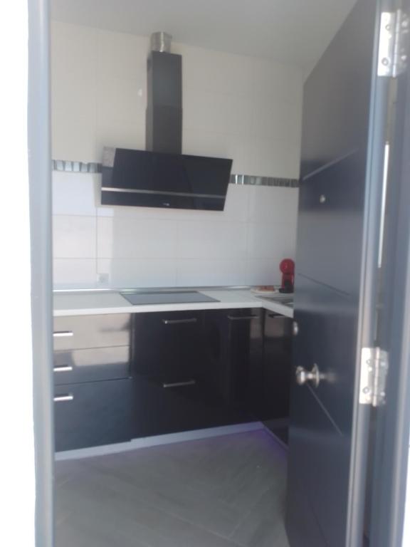 kuchnia z czarno-białą kuchnią w obiekcie Apartamento relax con piscina y jacussy spa w mieście Chiclana de la Frontera